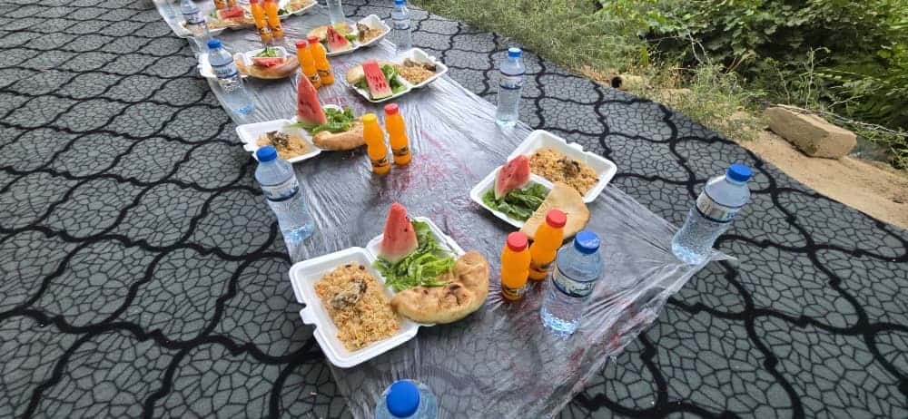 Aşure ikramı öncesi hazırlanan yer sofrası; naan ekmekleri ve ikramlar dizili